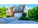 Lovely side view of a two-story brick home showcasing an attached two car garage and verdant landscaping at 155 Cottage Cir, Fayetteville, GA 30215