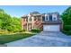 Beautiful two-story brick home with manicured lawn, attached two-car garage, and classic architectural details at 155 Cottage Cir, Fayetteville, GA 30215