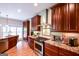 Well-equipped kitchen featuring wood cabinets, granite countertops, and stainless steel appliances for a modern and stylish cooking space at 155 Cottage Cir, Fayetteville, GA 30215