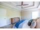 Inviting main bedroom featuring tray ceilings, ceiling fan, and a comfortable bed dressed in a blue blanket at 155 Cottage Cir, Fayetteville, GA 30215