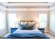 Comfortable main bedroom with two bedside tables, large windows, and bed dressed in a cozy blue blanket at 155 Cottage Cir, Fayetteville, GA 30215