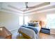 Well-lit main bedroom featuring tray ceiling and carpet flooring, decorated with side tables and large windows at 155 Cottage Cir, Fayetteville, GA 30215