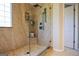 Shower with rainfall showerhead and marble surround accented by corner shelving and clear glass panel at 155 Cottage Cir, Fayetteville, GA 30215