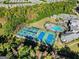 Aerial view showcases the tennis courts and pool adjacent to clubhouse; picturesque views of the surrounding landscape at 500 Cottonwood Cir, Peachtree City, GA 30269