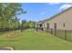View of a fenced-in backyard with a stone pathway, tree, and covered patio area at 500 Cottonwood Cir, Peachtree City, GA 30269