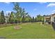 Well-manicured, fenced-in backyard featuring two trees with mulched rings and a stone pathway at 500 Cottonwood Cir, Peachtree City, GA 30269