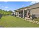 View of the covered patio with built-in grill, stone walkway, and lush, green, fenced-in backyard at 500 Cottonwood Cir, Peachtree City, GA 30269