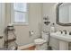 Bathroom features a pedestal sink, a decorative mirror, and a window for natural light at 500 Cottonwood Cir, Peachtree City, GA 30269
