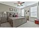 Comfortable bedroom with a ceiling fan, patterned bedding, and large windows at 500 Cottonwood Cir, Peachtree City, GA 30269