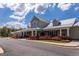 Exterior shot of a neighborhood clubhouse with stone accents, well maintained shrubbery and paved street at 500 Cottonwood Cir, Peachtree City, GA 30269