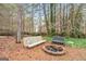 Backyard fire pit with bench seating, surrounded by trees and natural landscaping at 600 Lake Overlook Dr, Canton, GA 30114