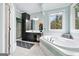 Bright bathroom featuring a tub, a separate shower, and a black vanity cabinet with dual sinks and a large window at 600 Lake Overlook Dr, Canton, GA 30114