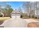 Two-car garage home featuring a well-manicured lawn, mature trees, and a curved driveway at 600 Lake Overlook Dr, Canton, GA 30114