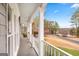 View from a covered porch with railings and posts overlooking street and mature trees at 600 Lake Overlook Dr, Canton, GA 30114