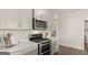Bright kitchen with stainless steel appliances, white cabinets and backsplash, and hardwood floors at 604 Parnassus Rd, Locust Grove, GA 30248
