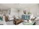 Living room features modern furnishings, light gray couches, a ceiling fan, and an entryway to a kitchen at 604 Parnassus Rd, Locust Grove, GA 30248