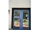 Exterior view of a white brick home with charming French doors with black trim and manicured landscaping at 3132 Riders Trl, Decatur, GA 30034