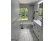 Renovated bathroom featuring marble-look tile, a white vanity, and a tub with shower at 3132 Riders Trl, Decatur, GA 30034