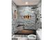 Luxurious bathroom featuring marble-tiled walls, a rain shower head, and a built-in shower seat for a spa-like experience at 3132 Riders Trl, Decatur, GA 30034