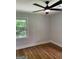 Bright bedroom with hardwood floors, ceiling fan, and a window with a view to a leafy yard at 3132 Riders Trl, Decatur, GA 30034