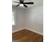 This bedroom features hardwood floors, a modern ceiling fan, and a window overlooking the greenery at 3132 Riders Trl, Decatur, GA 30034