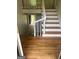 Well-lit staircase with hardwood steps, white risers, and a white banister leading to the upper level at 3132 Riders Trl, Decatur, GA 30034