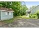 Backyard of the home with a shed, green trees, and a gravel driveway at 41 Ridgewood Cir, Mcdonough, GA 30252