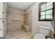 Bright bathroom featuring a tiled shower with a bench, a hand-held shower, and a window at 41 Ridgewood Cir, Mcdonough, GA 30252