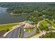 Aerial view showcases a clubhouse with tennis courts, a pool, parking, and lakeside scenery, nestled among trees at 130 Allie Dr, Mcdonough, GA 30252