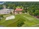 Aerial view of a clubhouse, golf course, and parking lot surrounded by trees and green landscape at 130 Allie Dr, Mcdonough, GA 30252