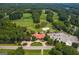 Aerial view of the golf course, clubhouse, and parking surrounded by lush greenery and trees at 130 Allie Dr, Mcdonough, GA 30252