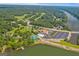 Aerial view displays the clubhouse, pool, and tennis courts near the lake, framed by lush trees and greenery at 130 Allie Dr, Mcdonough, GA 30252