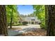 Stunning exterior view of a luxurious home with lush landscaping, mature trees, and a circular driveway at 130 Allie Drive, Mcdonough, GA 30252