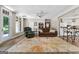 Open-concept living room with hardwood flooring, a ceiling fan, and access to a white kitchen at 130 Allie Drive, Mcdonough, GA 30252