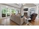 Comfortable living room with a brick fireplace, hardwood floors, large windows, and cozy seating arrangements at 130 Allie Drive, Mcdonough, GA 30252