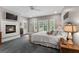 Bright main bedroom features a fireplace, soft carpeting, and a view of the outdoor landscape at 130 Allie Drive, Mcdonough, GA 30252