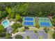 Aerial view showcasing a community swimming pool, tennis courts, and a parking lot surrounded by lush trees at 405 Highgrove Dr, Fayetteville, GA 30215