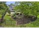 A backyard featuring a fenced fire pit, an in-ground pool, and plush green landscaping at 405 Highgrove Dr, Fayetteville, GA 30215