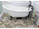 Close-up of a modern clawfoot bathtub with matte black fixtures and herringbone-patterned tile flooring at 405 Highgrove Dr, Fayetteville, GA 30215