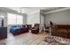 Spacious bedroom featuring wood-look floors, modern ceiling fan, and stylish dark colored furniture at 405 Highgrove Dr, Fayetteville, GA 30215