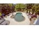 Aerial view of a kidney-shaped pool surrounded by lush landscaping, a stone patio, and plenty of seating at 405 Highgrove Dr, Fayetteville, GA 30215