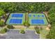 Aerial view of two well-maintained tennis courts with surrounding trees and a parking area for residents at 405 Highgrove Dr, Fayetteville, GA 30215