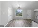 Inviting dining room with wood-look floors, neutral colors, and bright chandelier lighting is adjacent to kitchen cabinets at 1404 Meadowind Court Sw, Conyers, GA 30094