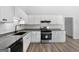 Bright kitchen featuring granite countertops, white cabinets, stainless steel appliances, and wood-look floors is modern and clean at 1404 Meadowind Court Sw, Conyers, GA 30094