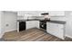 Modern kitchen with stainless steel appliances, granite counters, white cabinets, and wood-look flooring offers a fresh look at 1404 Meadowind Court Sw, Conyers, GA 30094