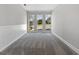 Empty room with carpet and three windows showcasing the exterior landscape at 1404 Meadowind Court Sw, Conyers, GA 30094