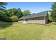 Spacious backyard with a well-maintained lawn and the rear exterior of the home at 1425 Meadowind Court Sw, Conyers, GA 30094