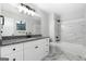 Bathroom with white marble, granite countertops, white cabinetry, and modern fixtures at 1425 Meadowind Court Sw, Conyers, GA 30094