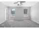 Bright bedroom featuring soft carpet, two windows, ceiling fan, and neutral walls at 1425 Meadowind Court Sw, Conyers, GA 30094