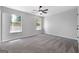 Carpeted bedroom with a ceiling fan and natural light streaming through the large windows at 1425 Meadowind Court Sw, Conyers, GA 30094